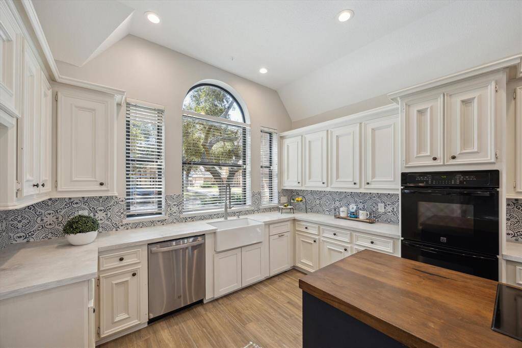 This chef’s dream kitchen blends beauty and function with double ovens, a charming farmhouse sink, classic white cabinetry, and durable quartz countertops. You also have double ovens.
