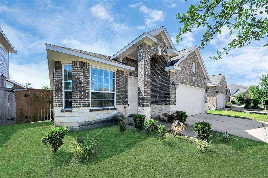 Charming single-story brick home with a neatly manicured lawn and a two-car garage. Features a welcoming front entrance and large windows allowing ample natural light.