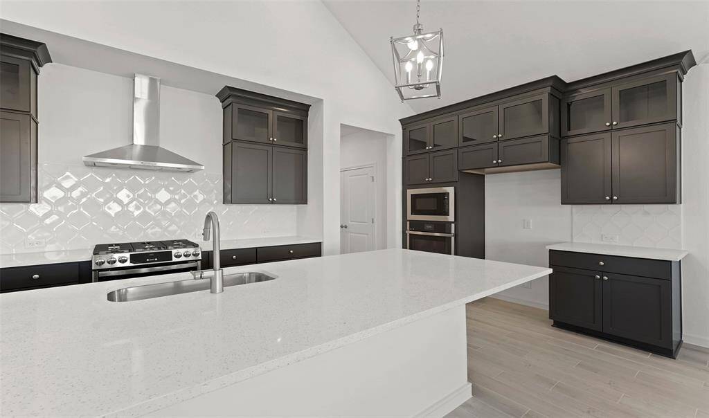 Island kitchen with grey cabinets and quartz countertops (*Photo not of actual home and used for illustration purposes only.)