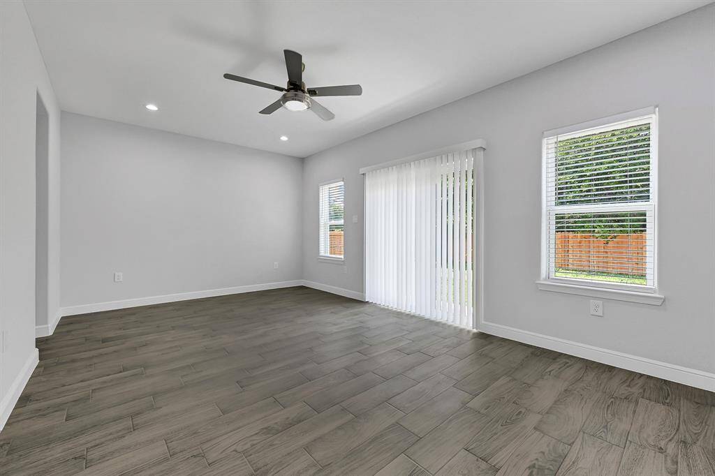 Spacious living area featuring hardwood floors and natural light.