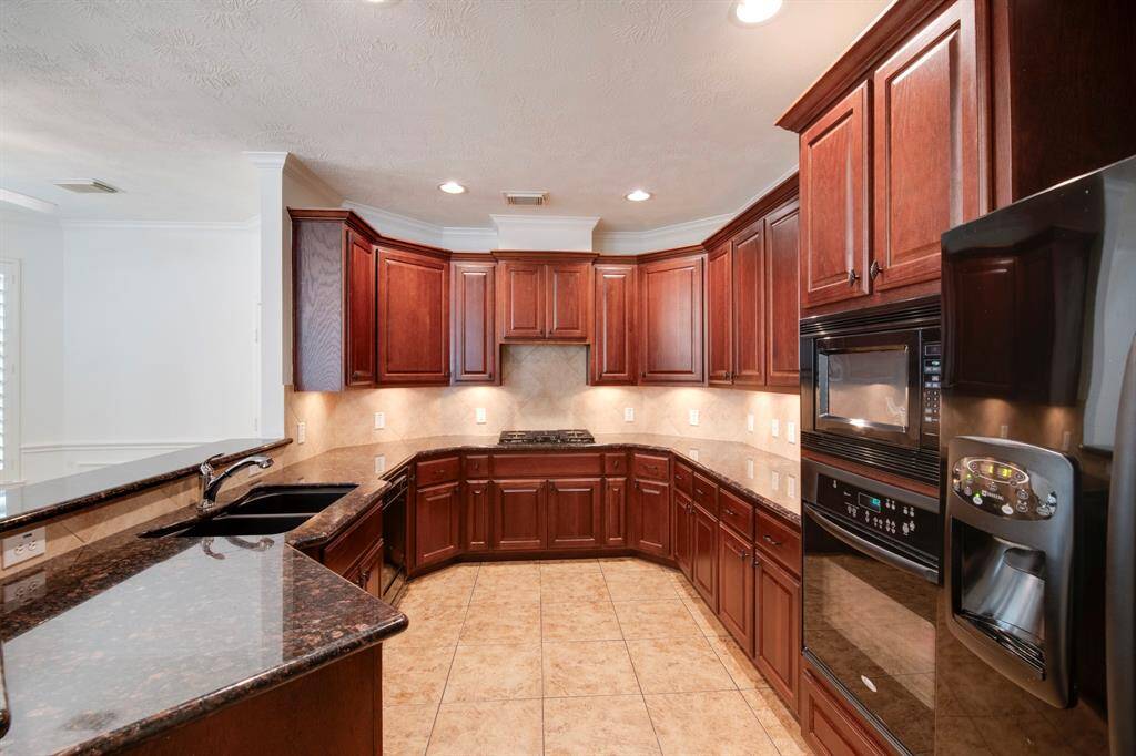 Kitchen has tile backsplash, under cabinet lighting, recessed lighting lighting. Refrigerator stays with the home.