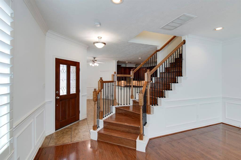 Foyer has glass paneled stained front entry door.