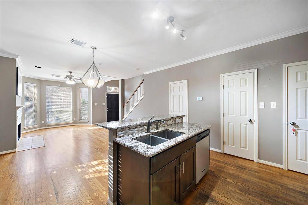 A central kitchen island features a convenient sink and doubles as a breakfast bar