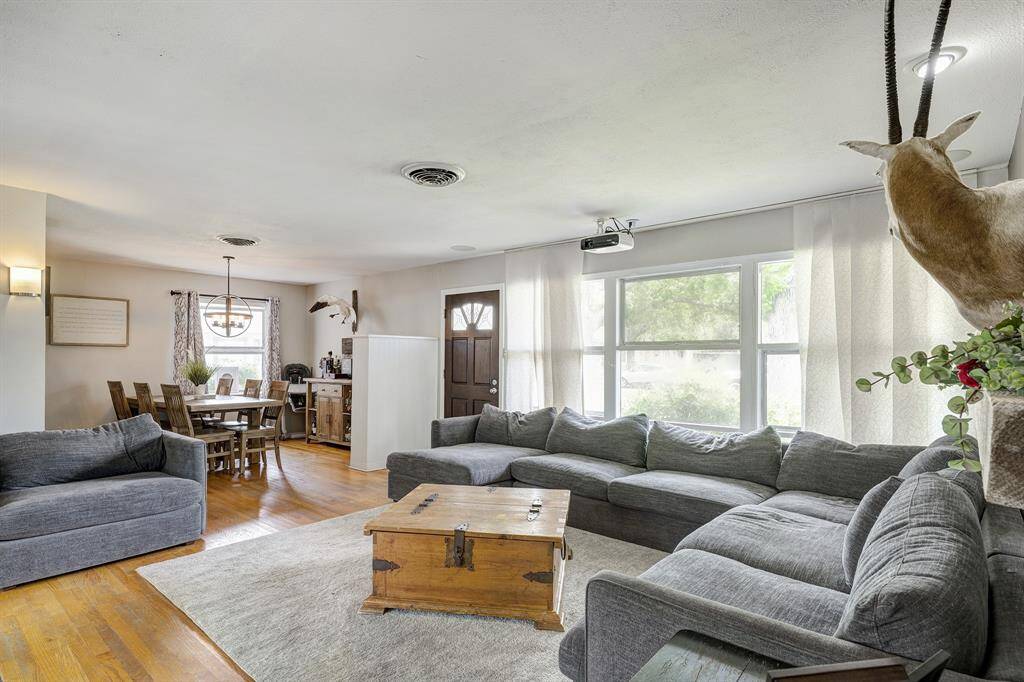 The living and dining space are open and airy with many windows allowing in natural light.