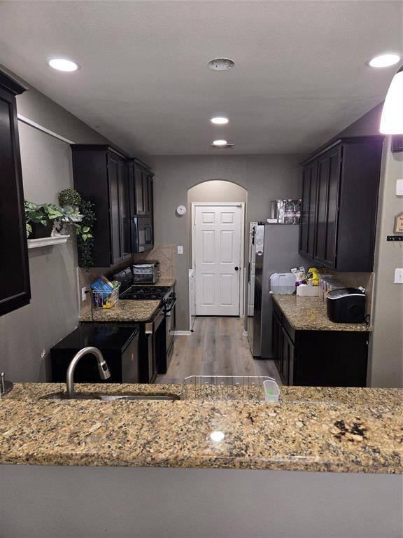 Granite counter tops, island bar, and walnut wood colored cabinets.