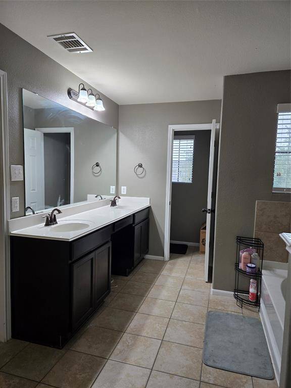 Primary bath with double sinks. Notice the vanity section in the center, just add you own stool.
