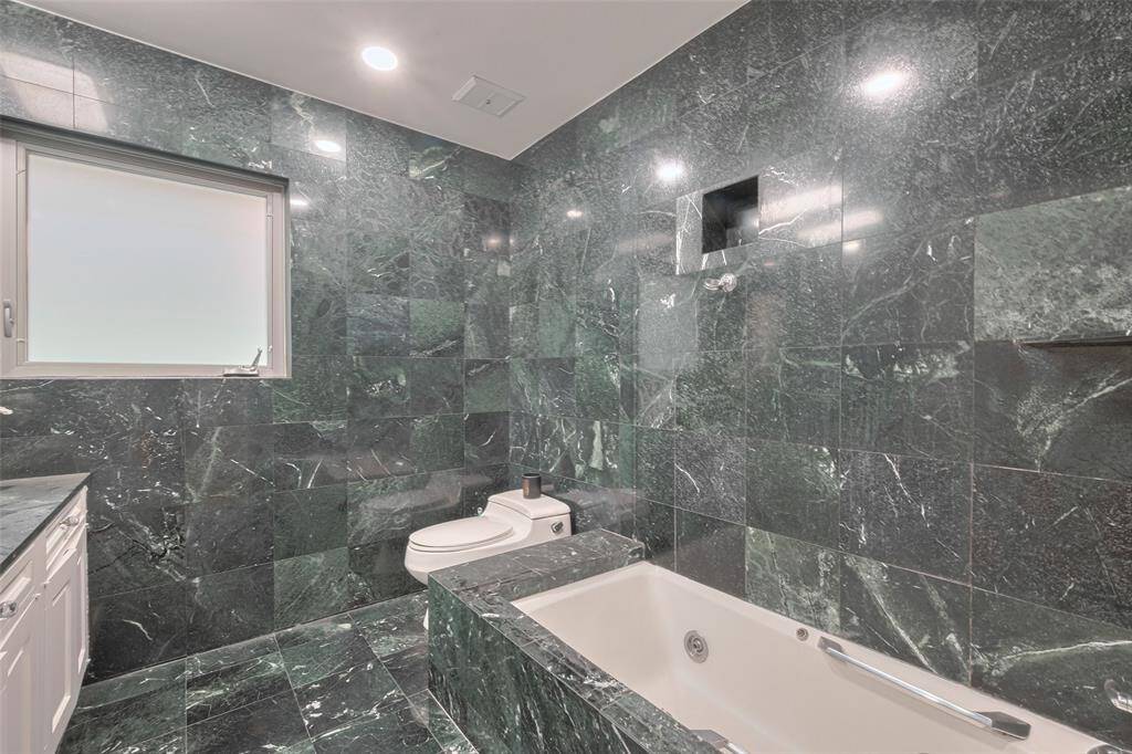 This Secondary room features hardwood floors, neutral walls, and two windows with blinds, providing natural light. It offers a spacious, versatile area ready for customization.