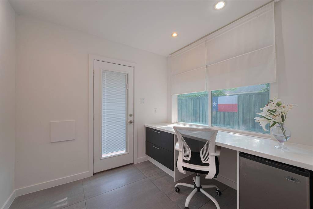 Bright home office located in the Garage apartment with a large window, modern desk. Adjacent room features a bedroom and a full bathroom. Perfect for guest.