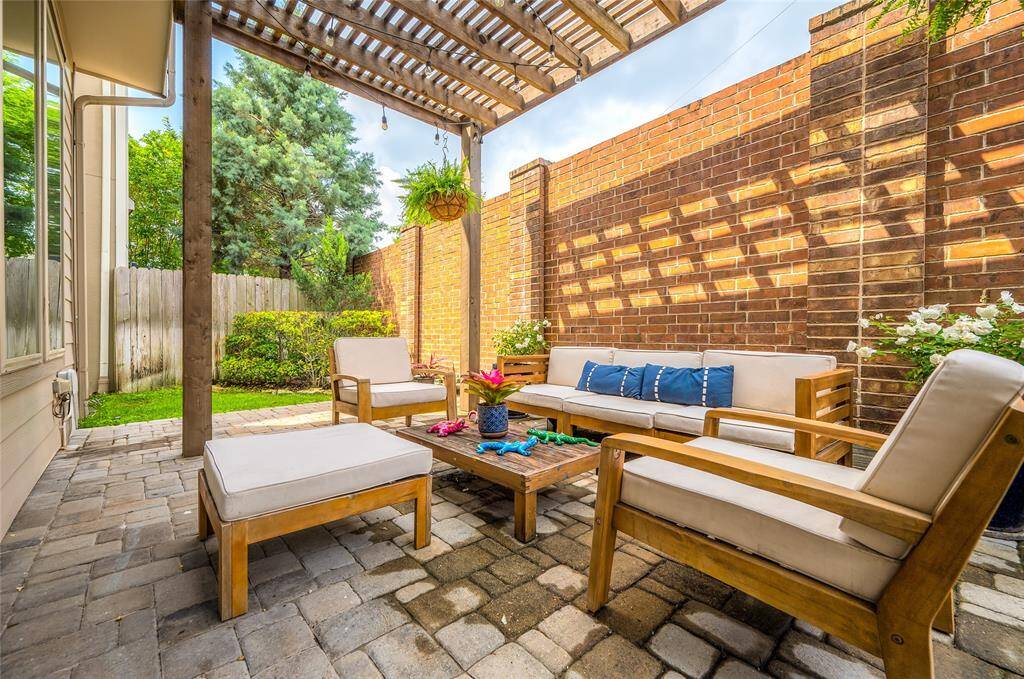 Enjoy outdoor living with a shaded pergola, extended paver patio, and grassy side yards—plenty of space for entertaining or play.
