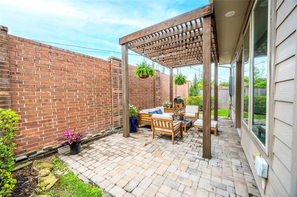 Fenced backyard with pergola, paver patio, and side yards—ideal for pets and outdoor gatherings.