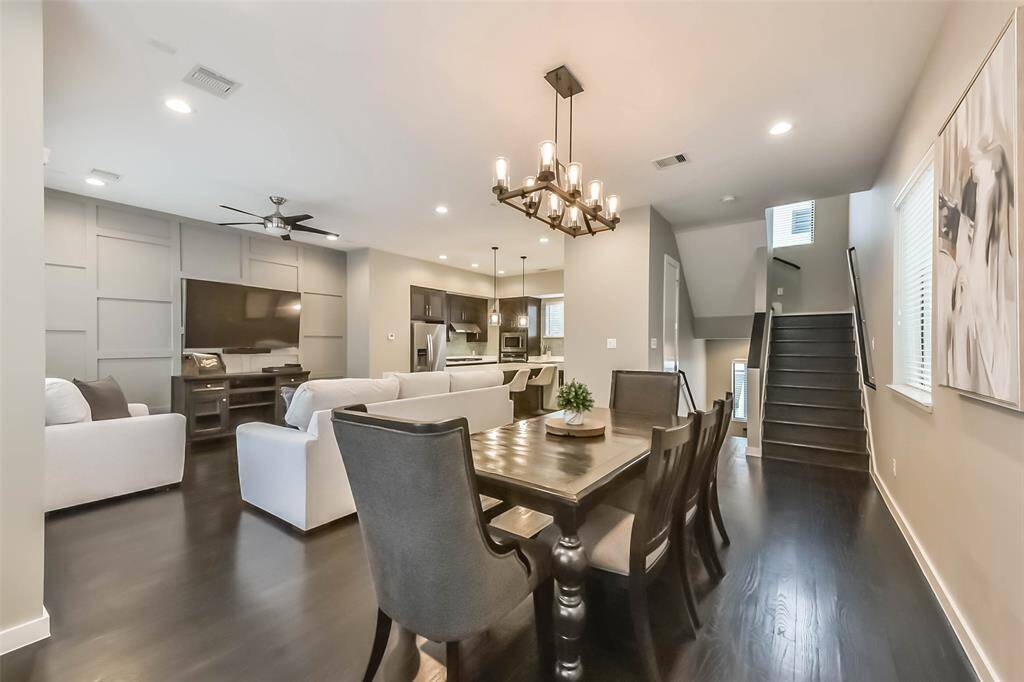 This open-concept living spacefeatures a stylish kitchen withdark cabinetry, quartzcountertops, a sleek island witha built-in wine fridge, andmodern pendant lighting. Thespacious living and dining areasboast elegant fixtures, recessedlighting, and large windows fornatural light. A neutral colorpalette, dark hardwood floors,and contemporary designelements create a sophisticatedyet cozy atmosphere, perfect forentertaining or relaxing.