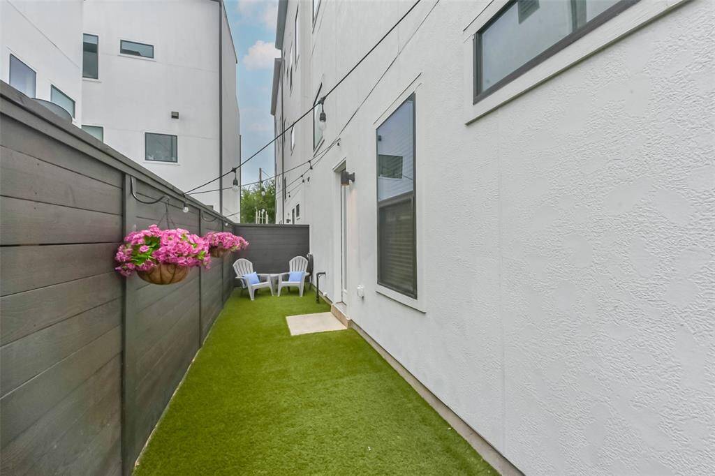This private backyard featureslow-maintenance turf, perfect forpets and outdoor relaxation.String lights add ambiance, whilethe dark wood fence andhanging flower baskets create astylish and inviting space. Enjoymorning coffee or unwind in thecozy seating area. Fullyenclosed for privacy, this yardoffers a charming retreat in theheart of the city.