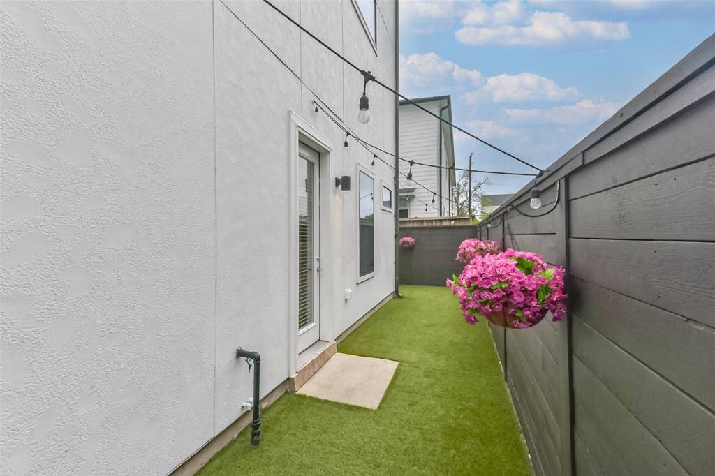 This private backyard featureslow-maintenance turf, perfect forpets and outdoor relaxation.String lights add ambiance, whilethe dark wood fence andhanging flower baskets create astylish and inviting space. Enjoymorning coffee or unwind in thecozy seating area. Fullyenclosed for privacy, this yardoffers a charming retreat in theheart of the city.