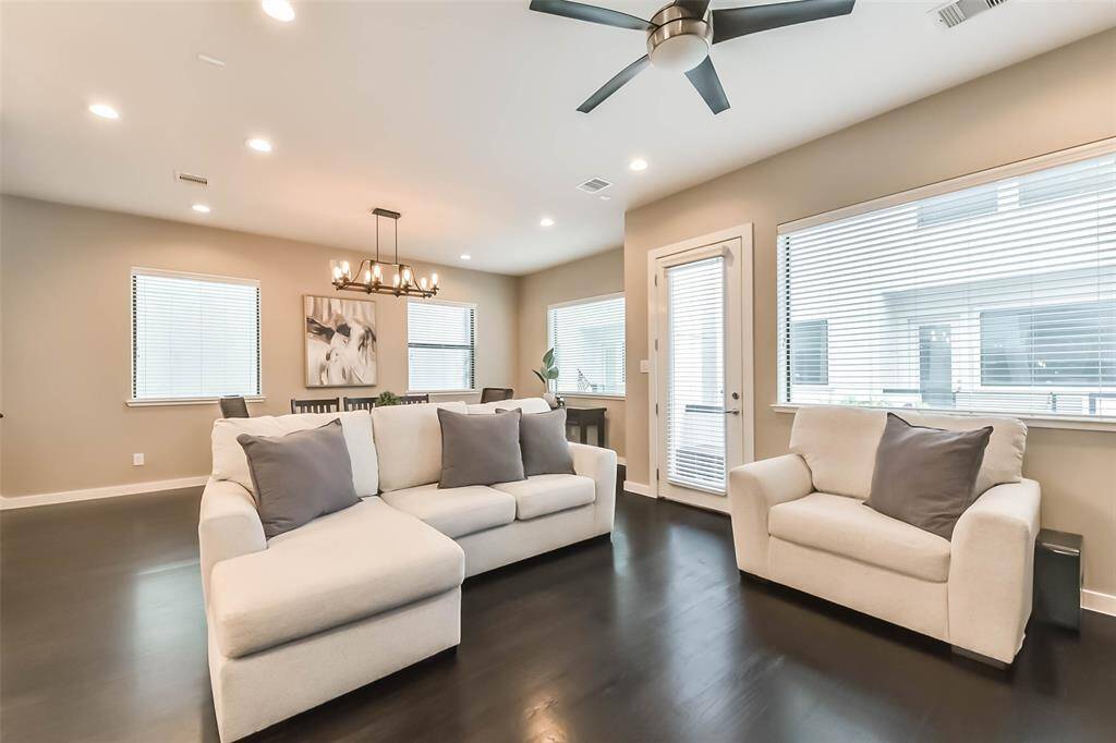 This open-concept living spacefeatures a stylish kitchen withdark cabinetry, quartzcountertops, a sleek island witha built-in wine fridge, andmodern pendant lighting. Thespacious living and dining areasboast elegant fixtures, recessedlighting, and large windows fornatural light. A neutral colorpalette, dark hardwood floors,and contemporary designelements create a sophisticatedyet cozy atmosphere, perfect forentertaining or relaxing.