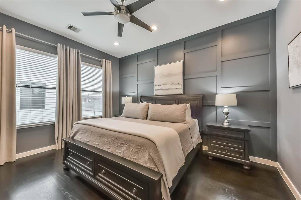 This stunning master bedroomoffers a serene retreat with abold accent wall, rich darkhardwood floors, and soft naturallighting. The spacious layout iscomplemented by a modernceiling fan and recessed lightingfor added comfort. Neutraldrapes frame large windows,providing both privacy andnatural light. A perfect blend ofsophistication and relaxation,this beautifully designed spacecreates a warm and invitingatmosphere.