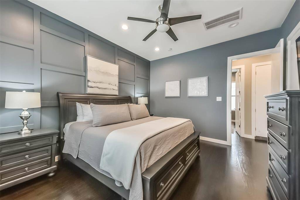 This stunning master bedroomoffers a serene retreat with abold accent wall, rich darkhardwood floors, and soft naturallighting. The spacious layout iscomplemented by a modernceiling fan and recessed lightingfor added comfort. Neutraldrapes frame large windows,providing both privacy andnatural light. A perfect blend ofsophistication and relaxation,this beautifully designed spacecreates a warm and invitingatmosphere.