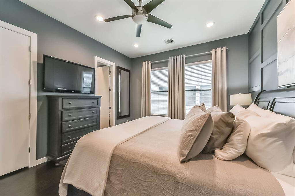 This stunning master bedroomoffers a serene retreat with abold accent wall, rich darkhardwood floors, and soft naturallighting. The spacious layout iscomplemented by a modernceiling fan and recessed lightingfor added comfort. Neutraldrapes frame large windows,providing both privacy andnatural light. A perfect blend ofsophistication and relaxation,this beautifully designed spacecreates a warm and invitingatmosphere.