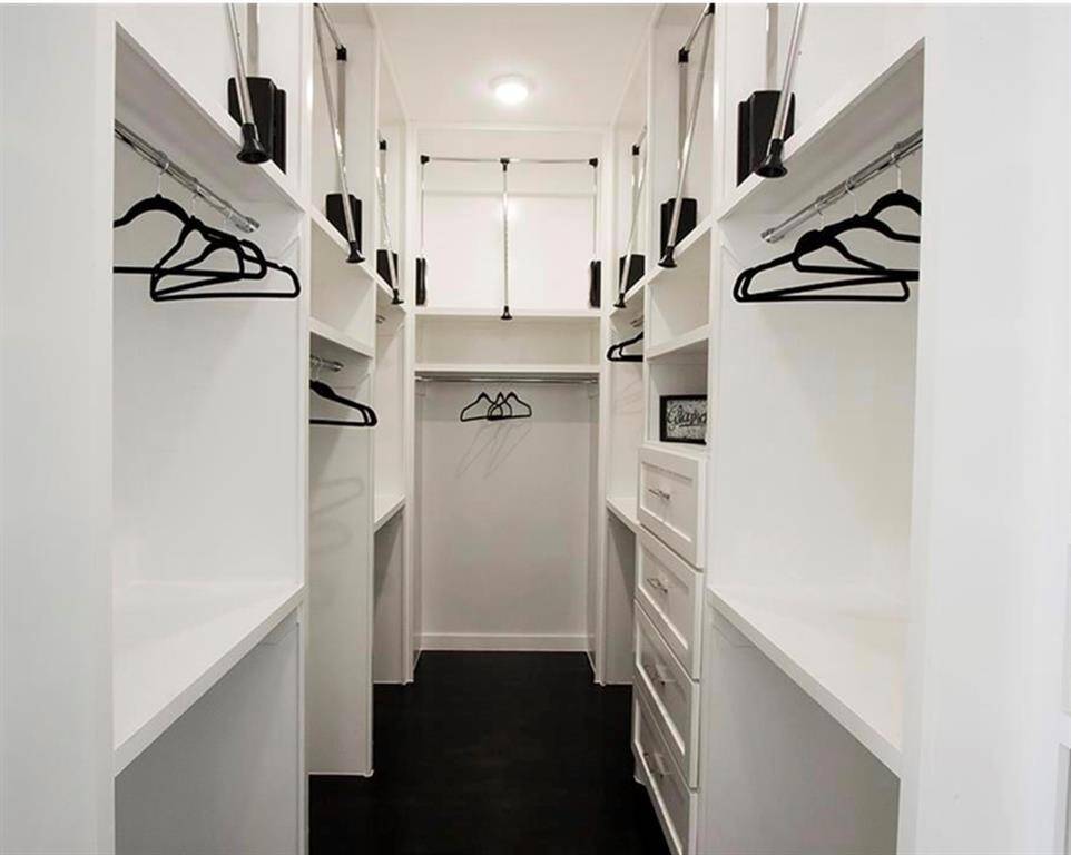 Spacious primary closet includes built-in shelving & pull down hanging rack for your entire wardrobe!