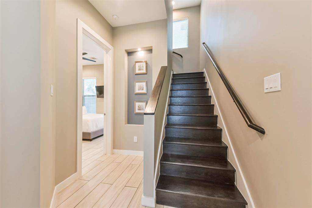 This thoughtfully designedentryway sets the tone for therest of the home with modernfinishes and elegant details.Sleek wood-look tile flooring andsoft gray walls create a warm,contemporary feel, while thedark wood staircase adds astriking contrast. A built-in artniche provides a sophisticatedtouch, and recessed lightingenhances the bright, openspace. With easy access to aguest bedroom and seamlessflow to the upper levels, thisentryway is both functional andwelcoming.