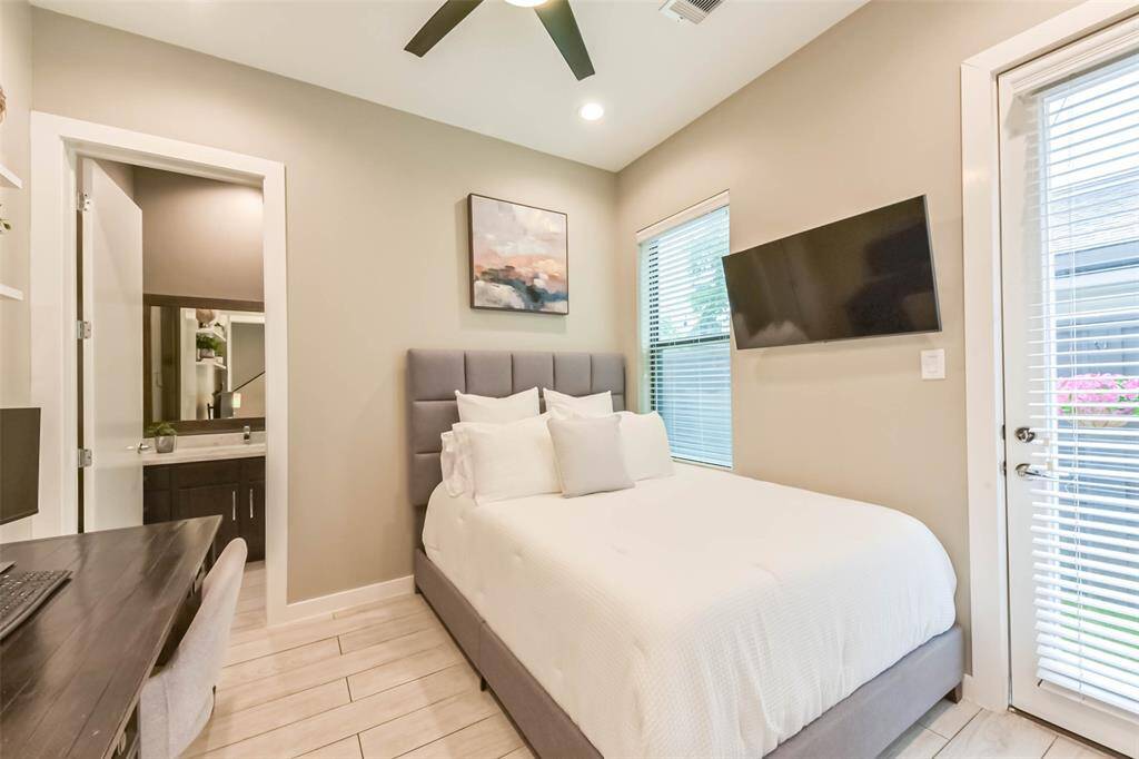 This first-floor bedroom offersprivacy and convenience,featuring direct access to theoutdoor space through a glasspaneled door. A large windowallows for natural light, whileneutral tones create a relaxingambiance. The en-suitebathroom and spacious layoutmake it an ideal guest suite orsecondary bedroom.