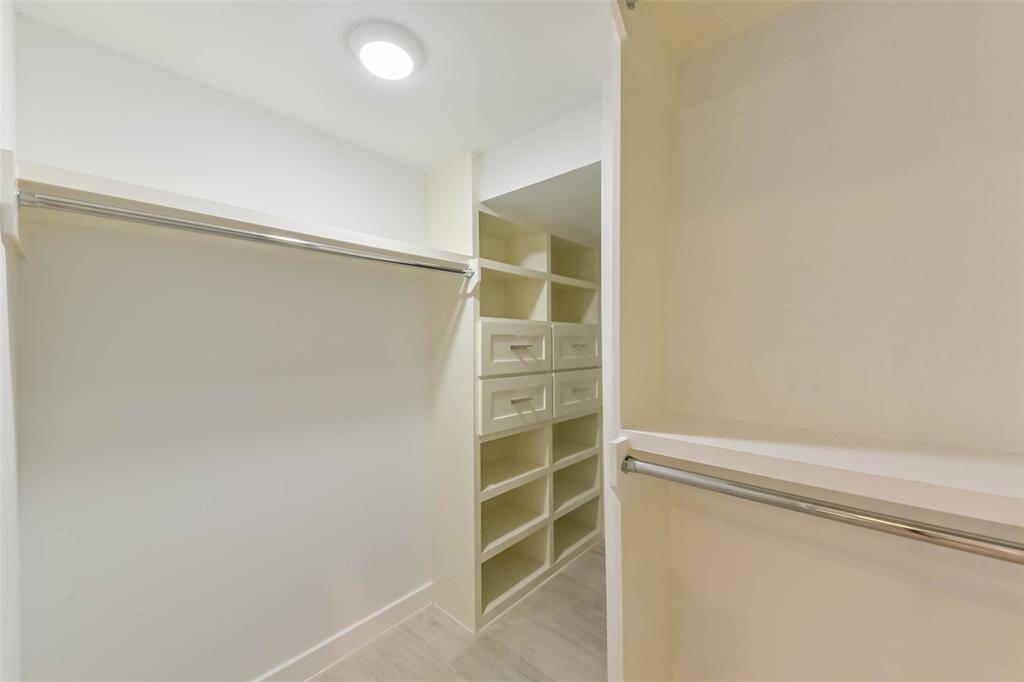This beautifully designed walk-in closet offers ample storage with built-in shelving, double hanging rods, and plenty of space to keep everything organized. Brightly lit and thoughtfully laid out, it provides both functionality and style—perfect for anyone who values a well-organized wardrobe.