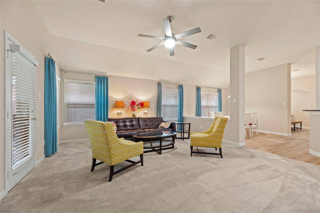 The family room offers plush carpet, ceiling fan and a gas log fireplace.