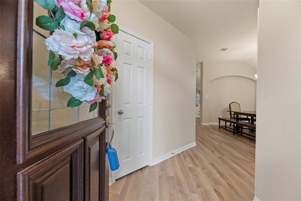Inviting front entry offers LVP flooring and neutral paint color.