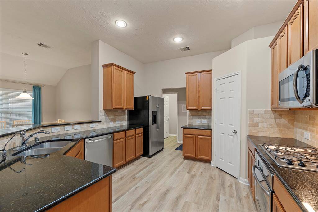 Another view of the kitchen with a large, corner pantry.