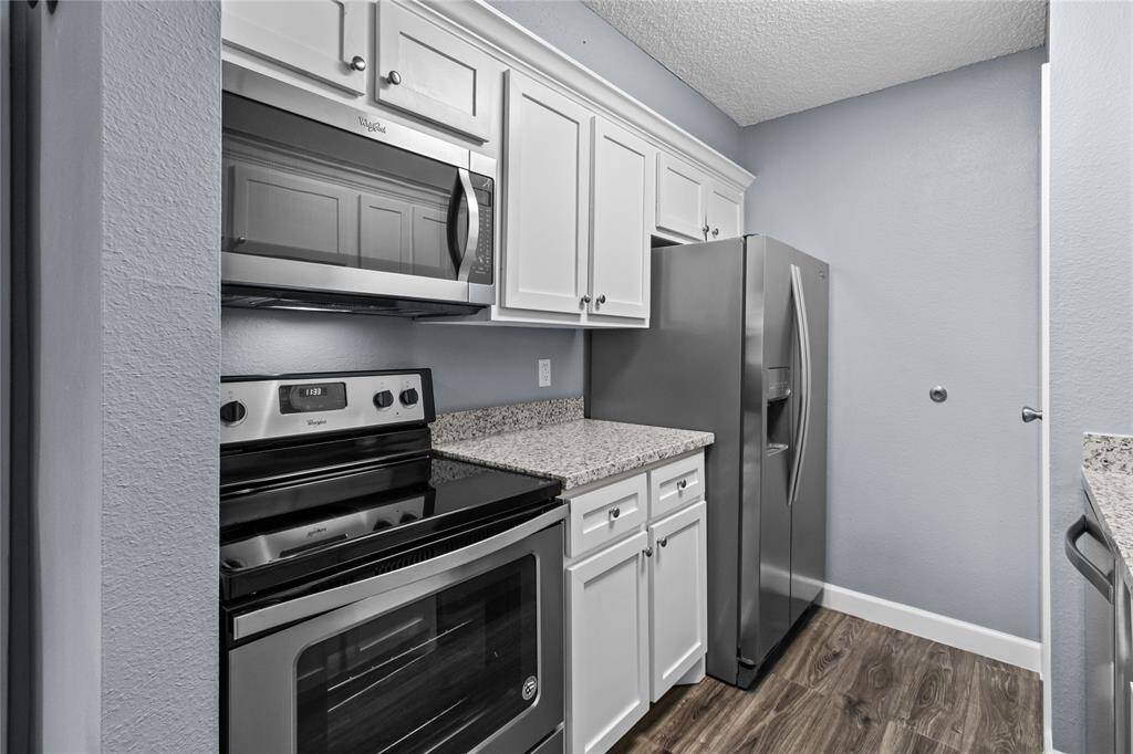 Updated kitchen includes granite, cabinet fronts, oven/range top, microwave and refrigerator.