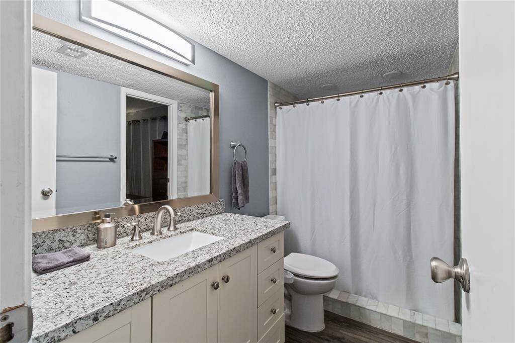 Updated cabinet with granite and another undermount sink and updated modern faucet.  Behind the shower curtain is a totally new walk in shower.  Will get another picture soon with the shower curtain open, the commode was also replaced AND the lighting and the hardware for towels.