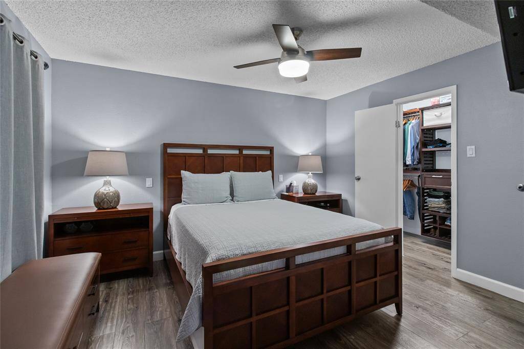 Primary suite picture #2 with a peak into the closet with built-in organization products.