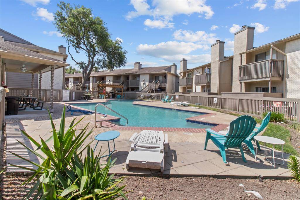 Condo swim pool with a covered area and picnic seating.