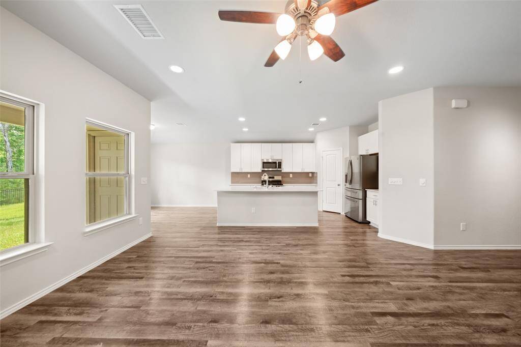 Primary spacious walk-in closet featuring built-in shelves and hanging rods, offering ample storage and organization options.