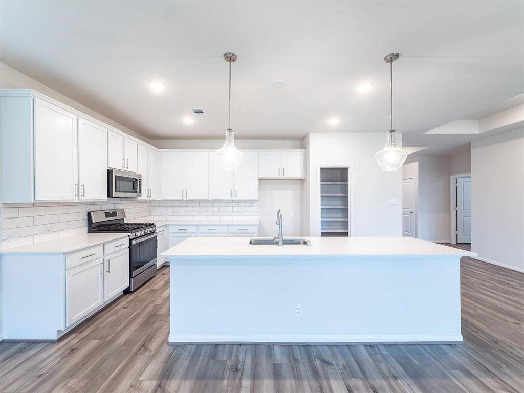 Large island kitchen with upgraded quartz & stainless appliances.