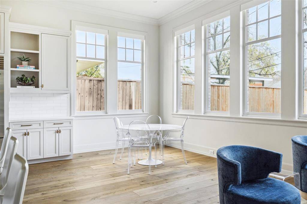 This thoughtfully designed kitchen extension offers ample space for a charming breakfast nook and a separate seating area. Surrounded by expansive windows, the space is bathed in natural light, creating an inviting setting for casual dining and relaxed gatherings.