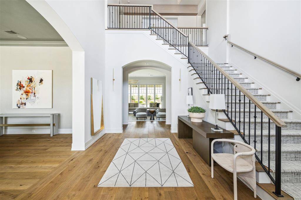 Step into a grand and inviting space where timeless sophistication meets refined elegance. The formal entry boasts gleaming oak hardwood floors and a soaring ceiling, creating a breathtaking first impression for any guest.