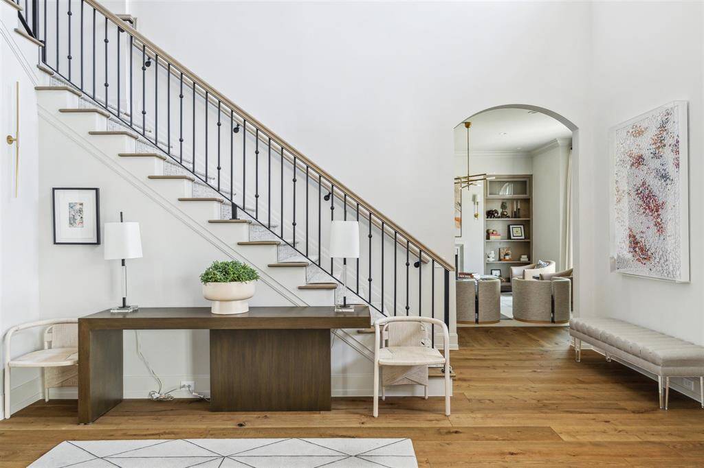 The grand entry showcases a striking staircase with a custom railing, complemented by white oak hardwood floors throughout. Designed with impeccable architectural details and high-end finishes, this stunning new build seamlessly blends rustic charm with refined elegance.