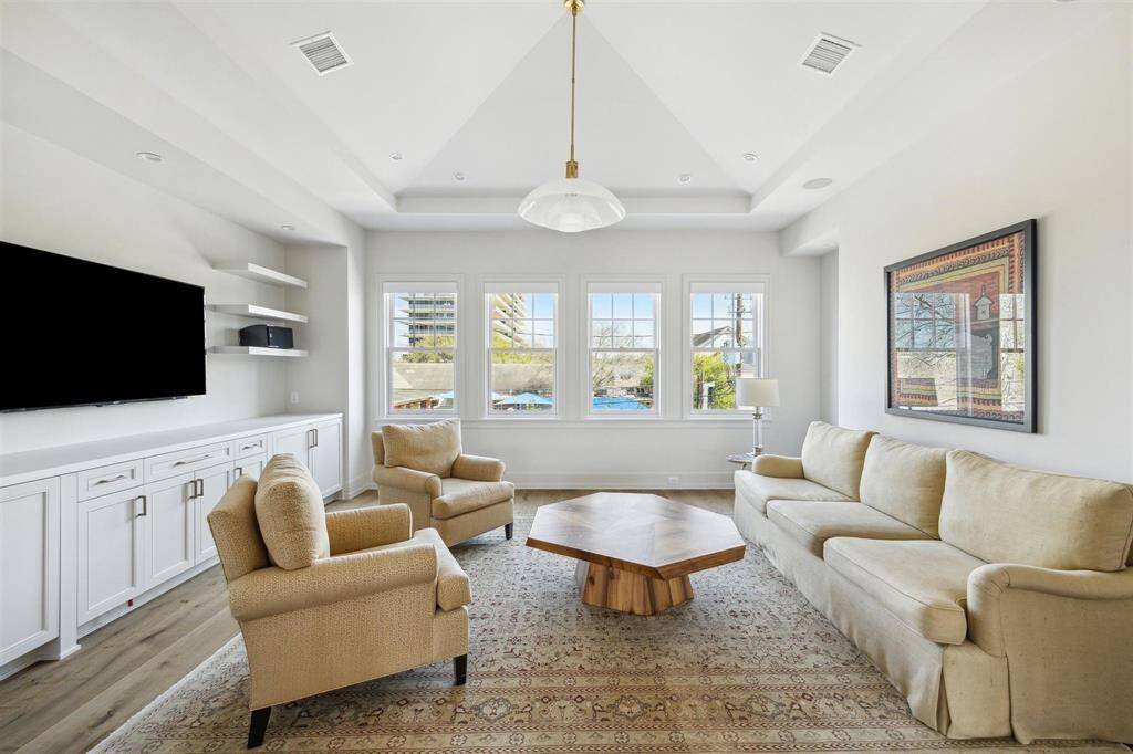 Host unforgettable movie nights in this perfectly positioned second-floor game room. Featuring rich hardwood floors, soaring tray ceilings, and a dedicated space for a personal home theater, this inviting space is designed for entertainment and relaxation.