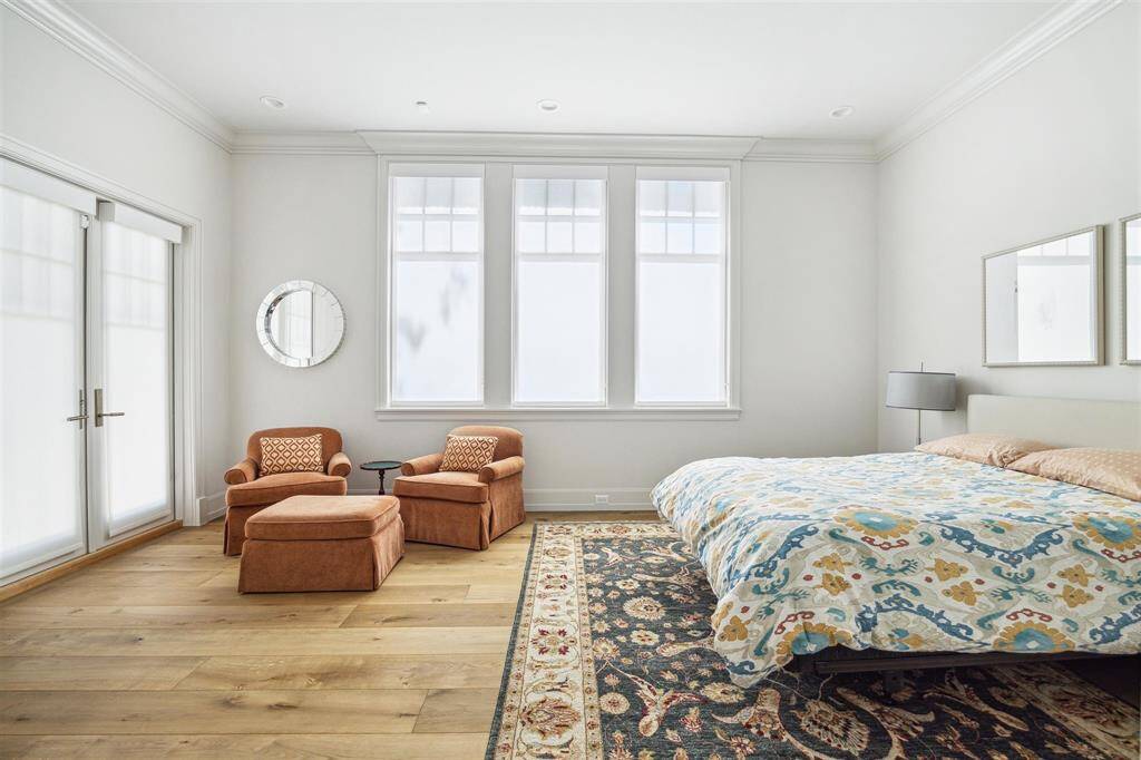 This inviting first-floor secondary bedroom is filled with natural light and offers direct backyard access through elegant French doors. Perfect for guests, the space features a spacious closet and a private en-suite bathroom for added comfort and convenience.