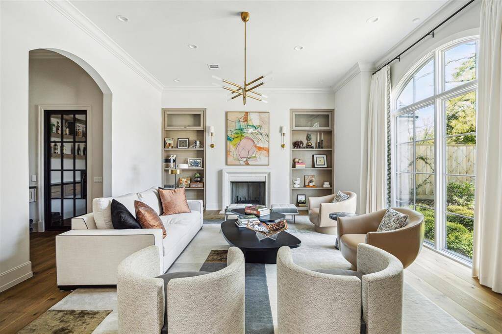 Overlooking the picturesque, tree-lined street, the light-filled formal living room or library radiates elegance with its wood-burning fireplace framed by a limestone mantel and beautiful white oak hardwood floors. Just steps away, an impressive wet bar is paired with a stunning, climate-controlled wine room—perfect for refined entertaining.