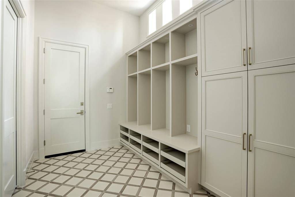 Designed for everyday ease, the mudroom offers generous storage and seamless access to the expansive three-car garage, making organization effortless.