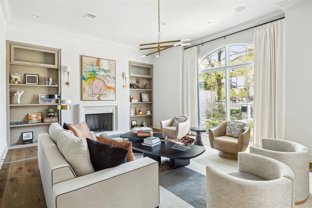 Designed for both elegance and functionality, the formal living room is anchored by a wood-burning fireplace with a stately limestone mantel. Custom-built rustic cabinetry and bookshelves add warmth and sophistication, providing ample space to display cherished books and artwork.