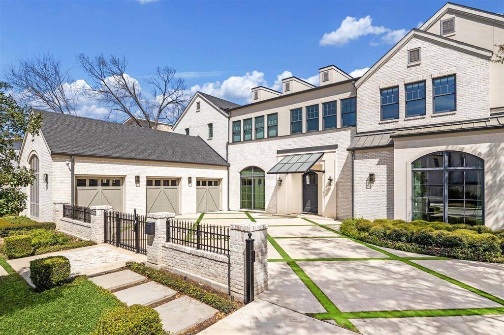 The fully enclosed front grounds are secured by an automatic gate, opening to a spacious motor court and oversized three-car garage. Meticulously designed landscaping enhances the home's striking exterior, creating an inviting and polished curb appeal.