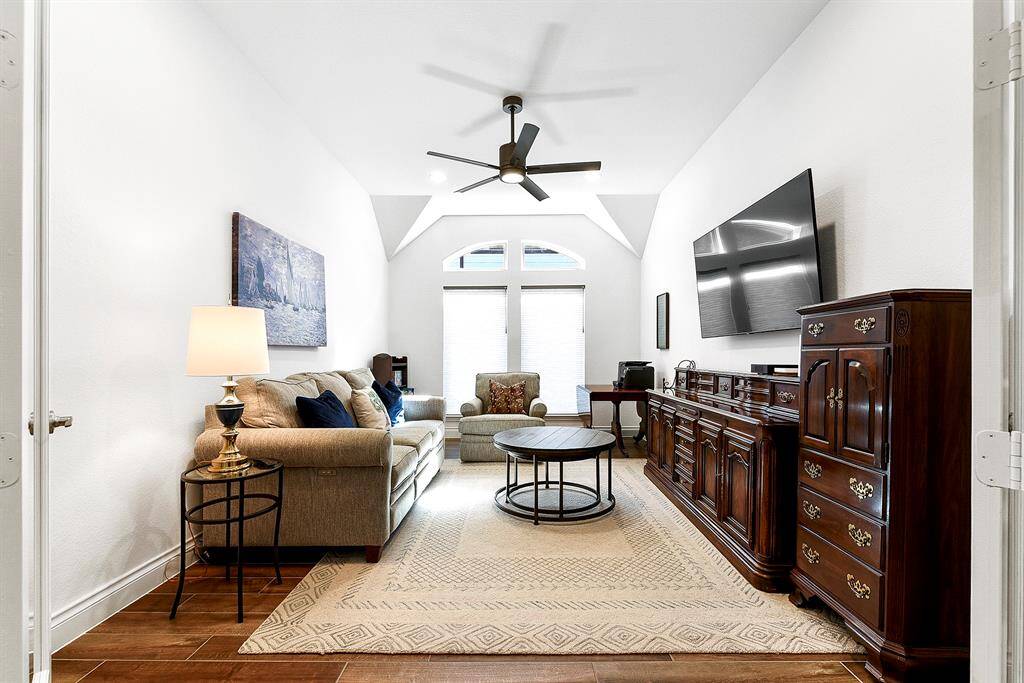Another view of this spacious Flex Room, featuring the same wood-like tile flooring and a 5-blade drop-down ceiling fan.