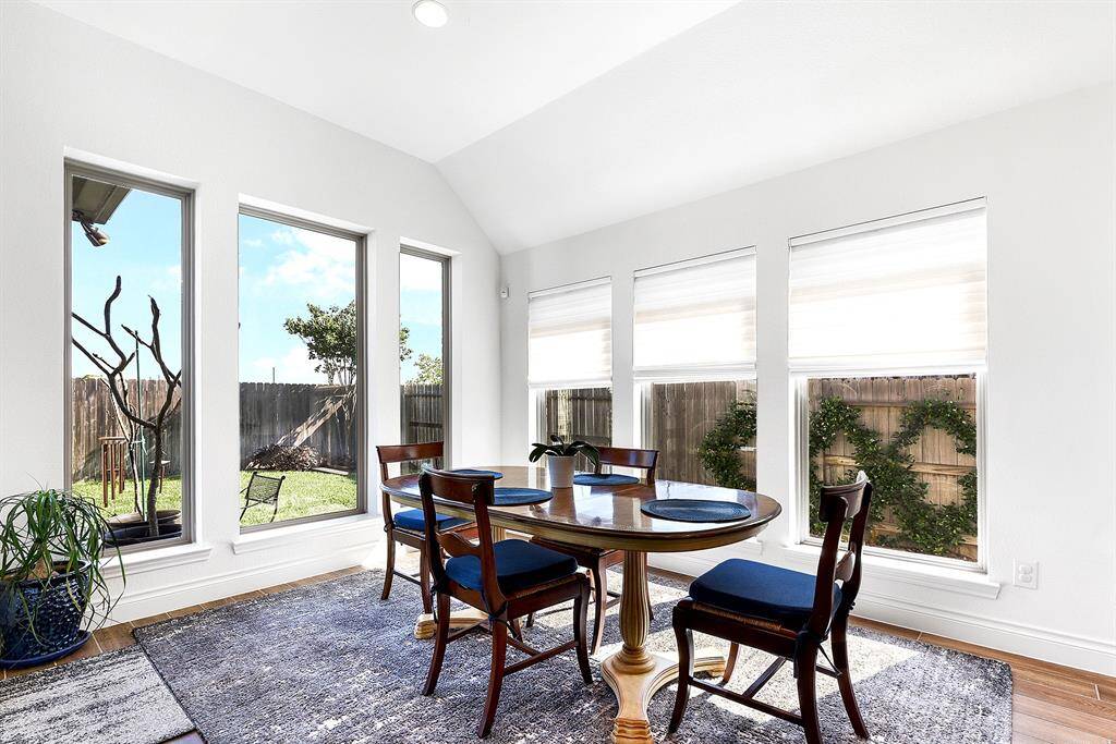The dining room offers easy access to the kitchen and is filled with natural light flowing in from the windows, providing relaxing views of the backyard.