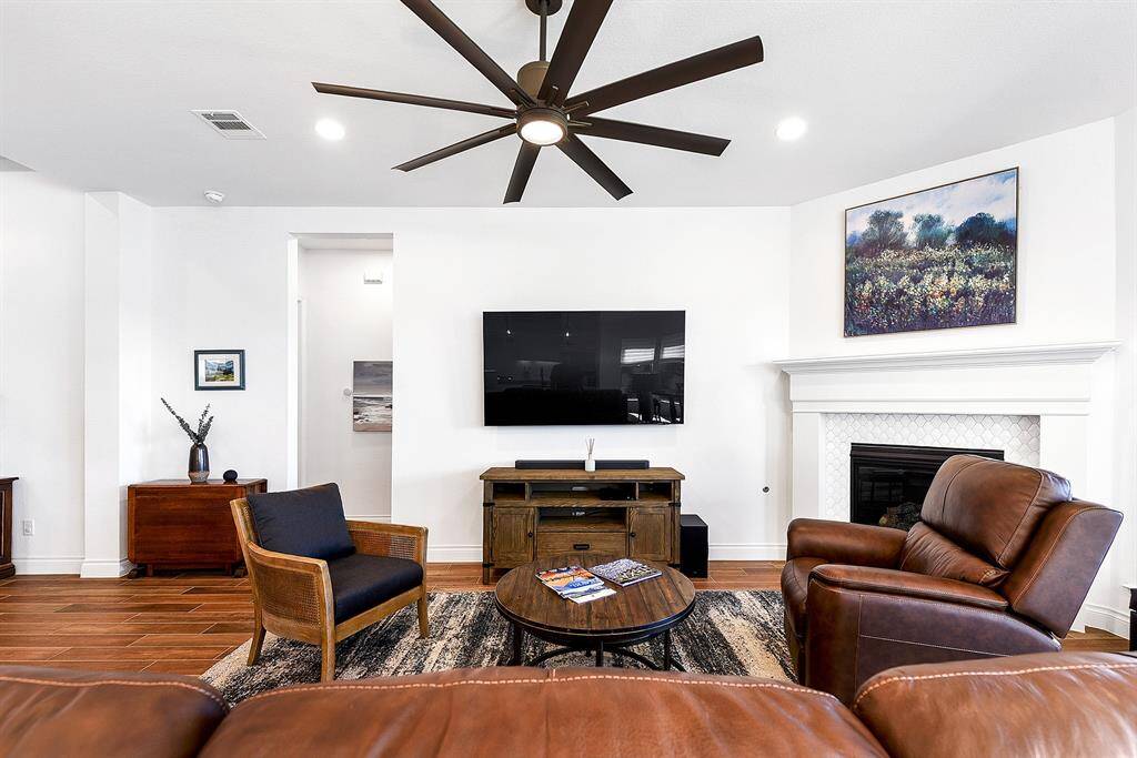 Another view of the living room highlights the spaciousness and high ceilings throughout the home. Tucked in the corner is the owner's retreat, offering a private and cozy escape.