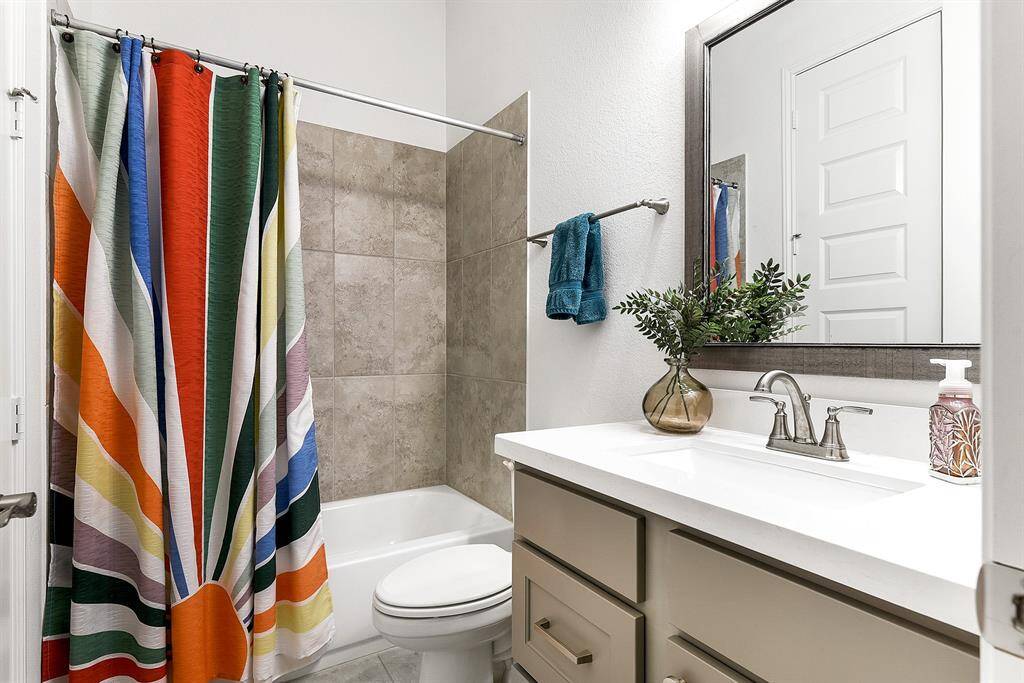 oth guest bathrooms feature a three-piece setup with a shower-tub combo and a full vanity sink.