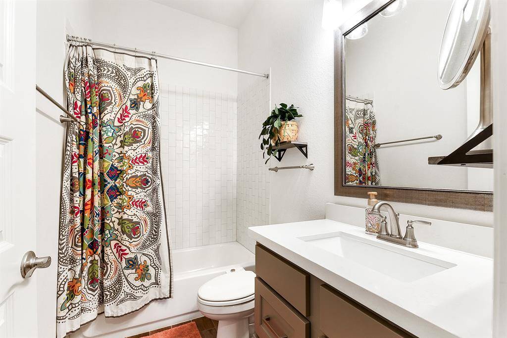 This home offers a total of 3 full bathrooms, with the guest bathrooms being just as gorgeous. They feature white quartz countertops, stylish hardware on the cabinetry, and framed mirrors for an added touch of elegance.