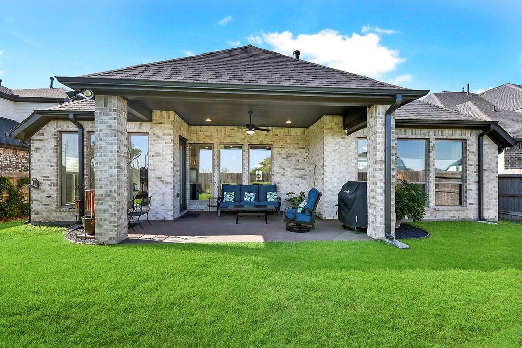 This huge center-covered patio offers a relaxing view, with a perfect vantage point of the backyard from the comfort of the well-planned space. The outdoor living area also features a ceiling fan and recessed lighting for added comfort and ambiance.