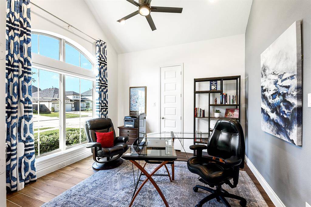 Another view of the spacious home office, highlighting the crisp white tones throughout and a stylish accent wall that adds character and charm to the space.